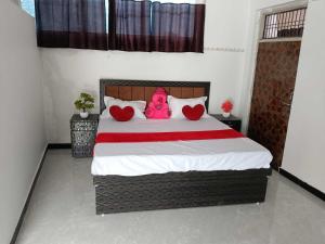 a bedroom with a bed with a pink doll on it at Hotel O Raj Family Restaurant & Hotels in Mahmūdnagar