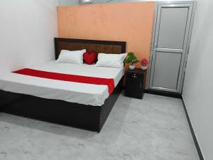 a bedroom with a bed with a red blanket at Hotel O Raj Family Restaurant & Hotels in Mahmūdnagar +7 photos