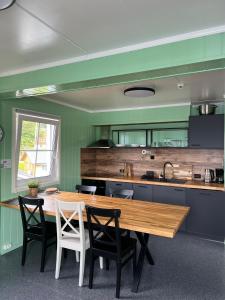 a kitchen with a wooden table and chairs at Martini Fishing Camp in Lauvsnes