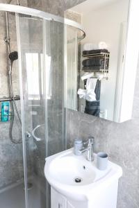 a bathroom with a white sink and a shower at 4 Guests - 2 Bedrooms - City Escape Retreat in Stoke on Trent