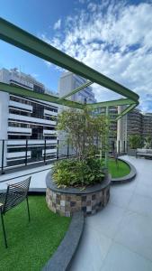 a patio with a bench and a tree on a building at Xtay Oslo Florianópolis - Residential studio 5 minutes from downtown, close to Epic School and Atlantis Executive Center in Florianópolis +36 photos