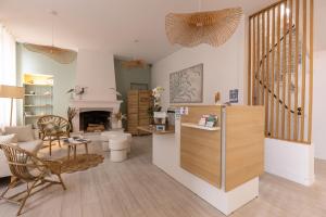 ein Wohnzimmer mit Tisch und Kamin in der Unterkunft Hôtel Le Square in Saint-Pierre-dʼOléron