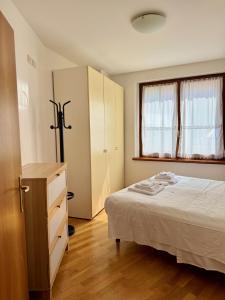 una camera da letto con un letto, un comò e una finestra di Accogliente Appartamento nel Centro Storico di Belluno, dietro Piazza delle Erbe a Belluno