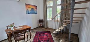 a room with a table and a staircase and a rug at Altes Saale Fährhaus in Naumburg +53 photos