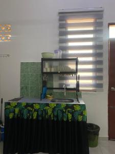 a kitchen with a counter with a sink and a window at Obah Homestay Kota Bharu in Kota Bharu +16 photos