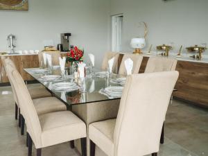 a dining room table with chairs and a glass table top at Humdani Safaris Free State in Virginia +11 photos