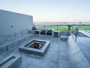 a patio with a fireplace with a view of the ocean at Humdani Safaris Free State in Virginia