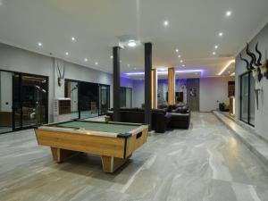 a living room with a pool table in the middle at Humdani Safaris Free State in Virginia