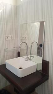 une salle de bains avec un lavabo blanc et un miroir dans l'établissement White Coconut Resort, à Gili Trawangan