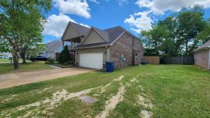 a house with a garage in a yard at Spacious, State Line, Private Pool with king Beds in Olive Branch +8 photos