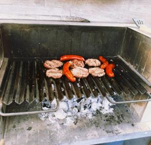 a group of sausages and carrots on a grill at TQCaleta Providencia Barrio Italia in Santiago