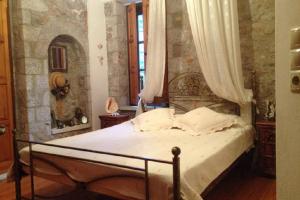 a bedroom with a large bed with a canopy at Leonidio Stone House in Pragmatevtís