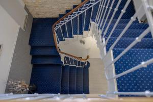 a blue staircase with a white stair case at Hôtel Le Square in Saint-Pierre-dʼOléron