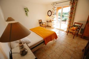 une chambre avec un lit et une lampe sur une table dans l'établissement Les Villas de Perret, à Joyeuse 70 autres photos