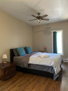 a bedroom with a bed with blue pillows and a ceiling fan at Maple Tree Oasis 2 bedroom in Pickering in Pickering