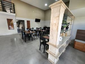 a dining room with tables and chairs and a fireplace at Hotel Villa Real in Piratininga