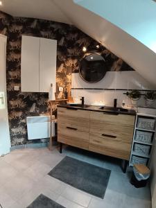 a kitchen with a sink and white cabinets at CHEZ HÉLÈNE in Saint-Coulomb