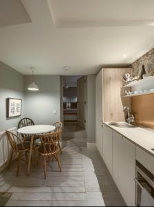 Una cocina y un comedor con mesa y sillas. en Shipmaster's Townhouse, en Queensferry