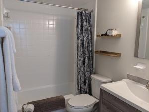 a white bathroom with a toilet and a sink at Shortest Walk to Shands and UF Health - Quiet, Equipped, Reliable - Free Parking in Gainesville