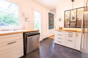 a kitchen with white cabinets and a window at Séjour haut en couleurs in Cormery +13 photos