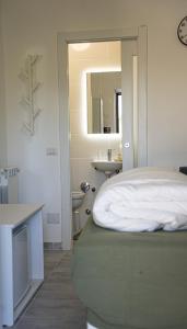 a bedroom with a bed and a sink and a mirror at la casa di fatima in Campoleone