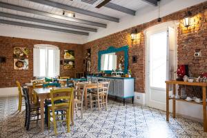 a dining room with tables and chairs and a brick wall at Palazzo ReSilente in Castelnuovo Cilento