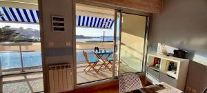 a room with a balcony with a view of the ocean at Studio Vue imprenable sur la Mer et les 7 Iles in Trévou-Tréguignec +21 photos