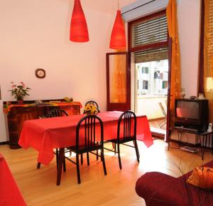 a dining room with a red table and chairs at B&B Arabesque in Venice