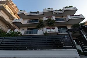ペスカーラにあるAttico fronte mare con terrazzoの階段とヤシの木が目の前に建つ建物