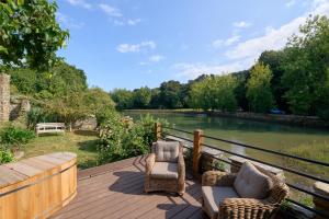 two chairs sitting on a deck next to a river at The Boathouse - Salcombe - Spring Time Tiny Home in Salcombe