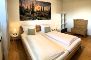 a bedroom with a large bed and a painting on the wall at Ferienhaus Kirchl in Hohenau
