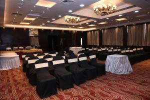 a banquet hall with tables and chairs and chandeliers at The Maureen in Kolkata