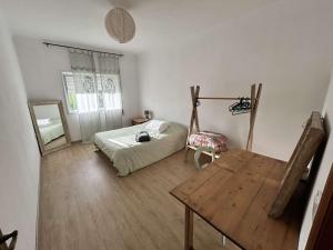 una camera da letto con un letto, un tavolo e uno specchio di Casa Da Alice a Duas Igrejas