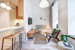 ein Wohnzimmer mit Stühlen und einem Tisch sowie eine Küche in der Unterkunft Domillion Studio Modern Old Town Retreat So1b in Vilnius
