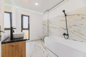 un bagno bianco con vasca e lavandino di KOA - Street a Braşov Altre 55 foto