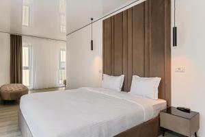 a bedroom with a large bed with white sheets at KOA - Street in Braşov