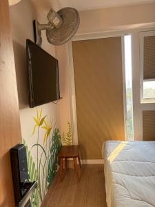 a bedroom with a bed and a flat screen tv on the wall at Thien Hai Home in Quy Nhon