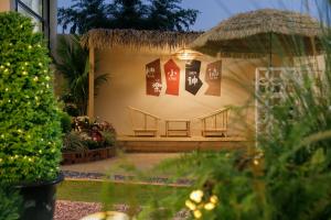 ein kleines Haus mit Stühlen und einem Sonnenschirm in der Unterkunft Xiangwang Hotel Shanghai Airport 24H Free Shuttle in Shanghai