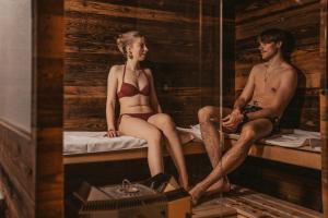a man and woman sitting on a bed in a sauna at Palace Luxury Wellness Apartment and Boutique Hotel Ski-in-out in Saas-Fee