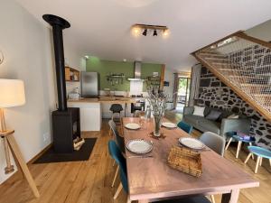 a kitchen and living room with a table and a stove at L'Écrin Volvicien - Maison 4 pers - Terrasse - Jardin in Volvic