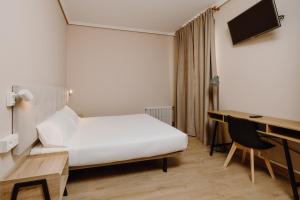 a hotel room with a bed and a desk at Hotel Convento de Miranda in Miranda de Ebro