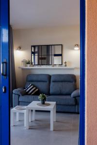 a living room with a blue couch and a table at Casa Guillaume in Mogán +69 photos