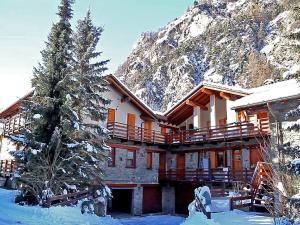 a building in the snow with a tree in front of it at Apartment in Antey-Saint-André near Ski Lift in Antey-Saint-André