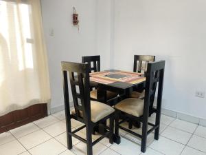 a dining room table with three chairs and a table and chairsktop at Espacioso,Balcón Privado,Cerca Plaza Principal in Santa Cruz de la Sierra +9 photos
