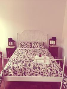 a bedroom with a white bed with a black and white bedspread at Casa dos Pátios II in Aveiro