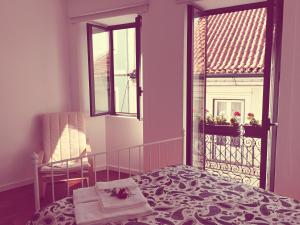 a bedroom with a bed and a window and a chair at Casa dos Pátios II in Aveiro