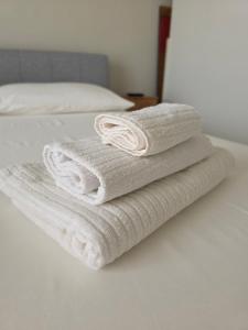 a stack of towels sitting on a bed at Casa Dream - Milan in Cesano Boscone