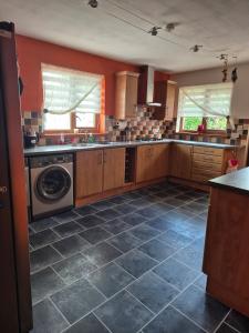 a kitchen with a washer and a washing machine at The Yard Bungalow in Sanquhar