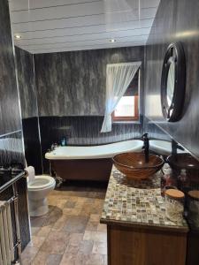 a bathroom with a tub and a toilet and a sink at The Yard Bungalow in Sanquhar