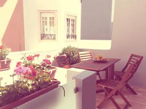 a balcony with a table and chairs and flowers at Casa dos Pátios II in Aveiro